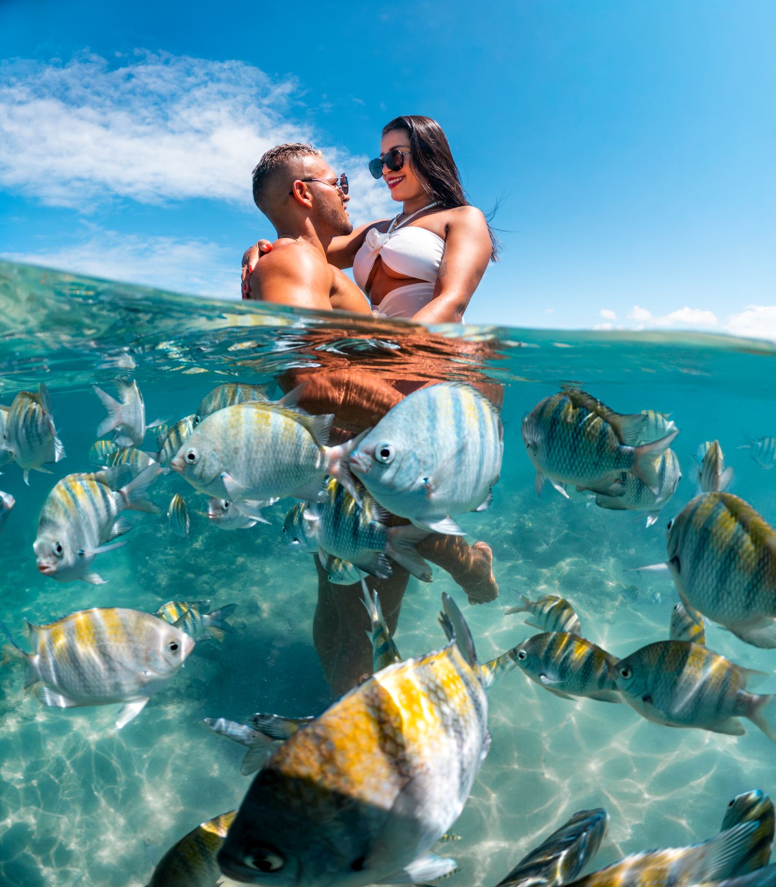 Ensaio subaquático de casal entre os peixes das piscinas naturais