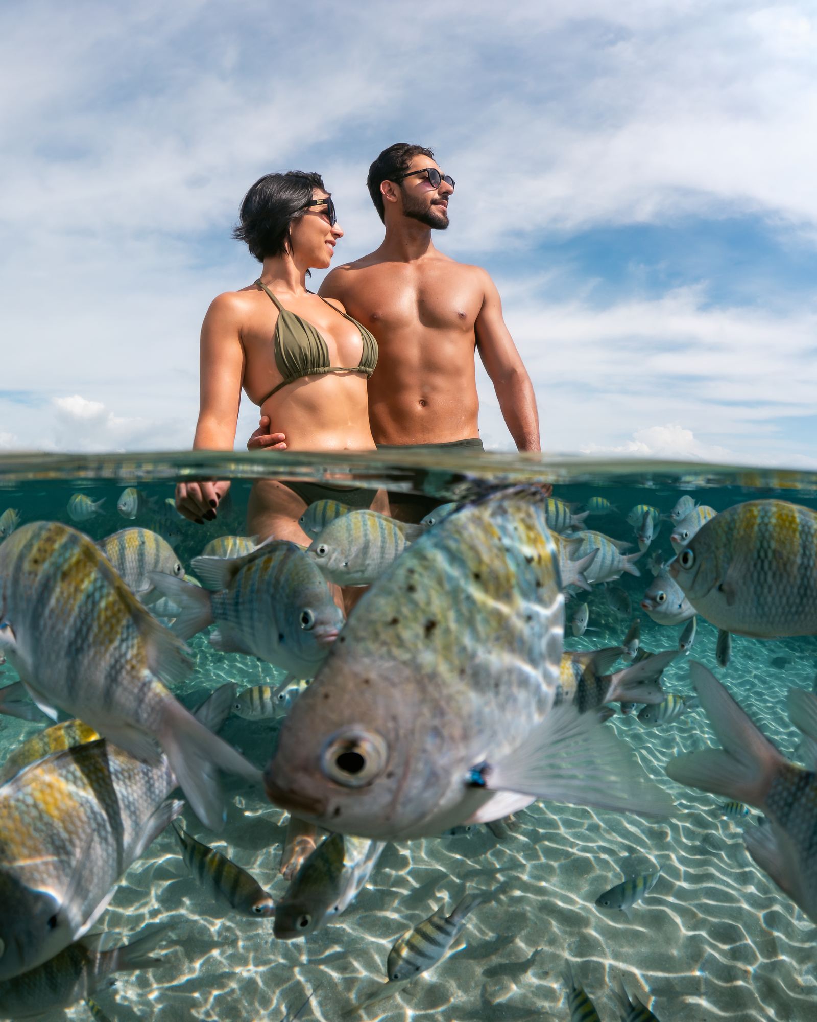 Ensaio subaquático de casal entre os peixes das piscinas naturais