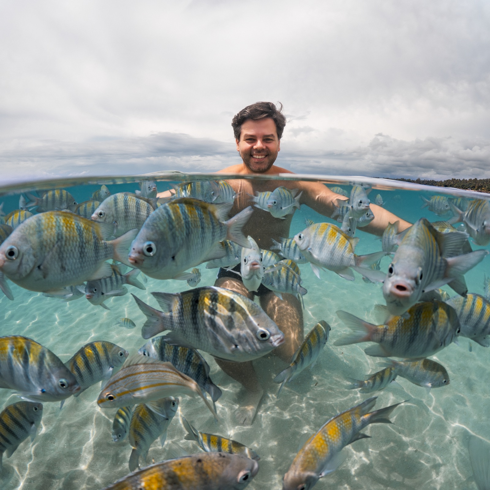 Ensaio subaquático masculino entre os peixes em Morro de São Paulo