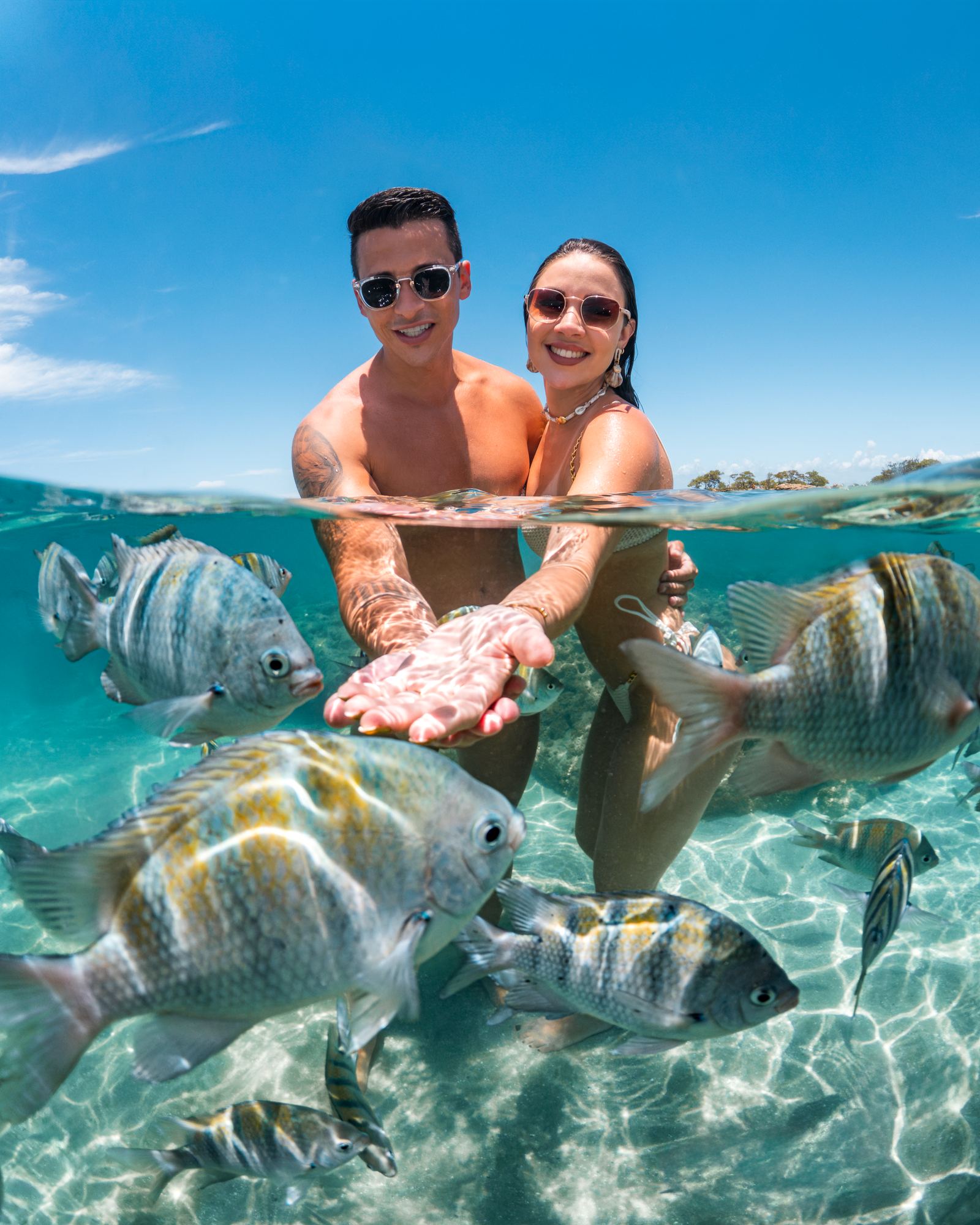 Ensaio subaquático de casal entre os peixes das piscinas naturais