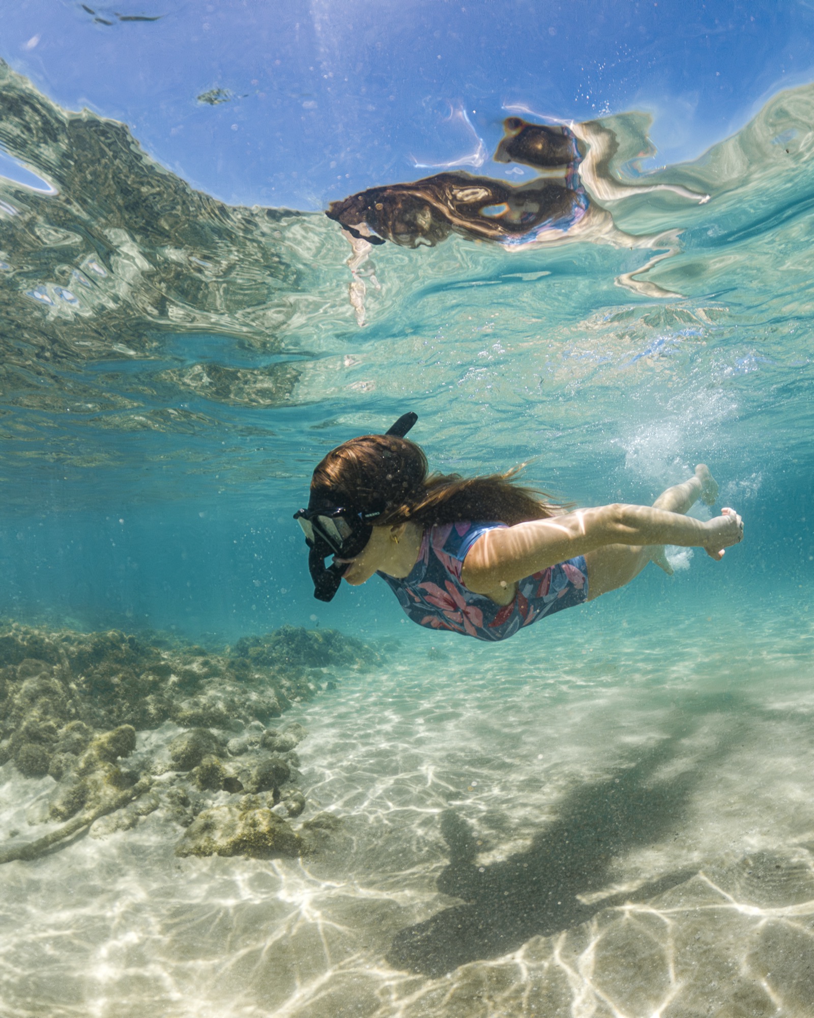 Ensaio subaquático de casal entre os peixes das piscinas naturais